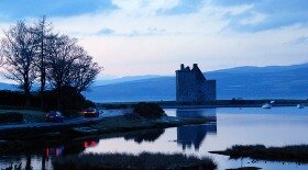 Lochranza Castle in dusk, with the Kintyre hills in the background